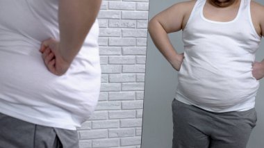 Obez adam önünde poz ayna, kas gibi davranarak, fitness ve diyet