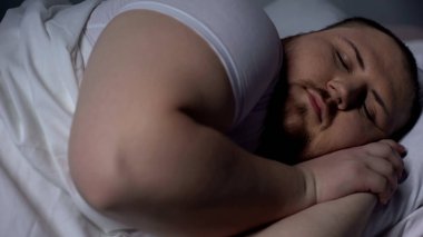 Closeup of obese man sleeping peacefully, relaxing on comfortable mattress clipart