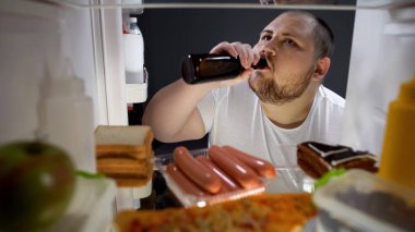 Obez adam gizlice içki bira şişesinden buzdolabı gece, diyet hatası