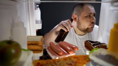 Şişman erkek gizlice bira şişesinden buzdolabına gece, sağlıksız yaşam tarzı çekici