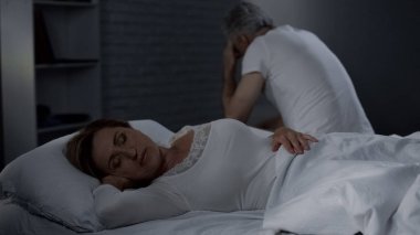 Yaşlı Bayan uyku, geriye doğru kadar yatağın kenarında oturan koca, Erkekler Sağlık