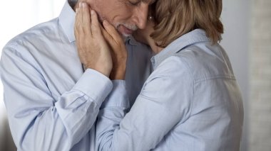 Yaşlı erkek ve dişi kucaklayan, Bayan çukurluğu erkek yanak, mutlu uzun evlilik