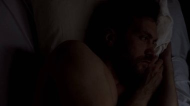 Uykusuzluk acı ki, yatakta yalnız yalan, sorunlar hakkında üzgün genç erkek