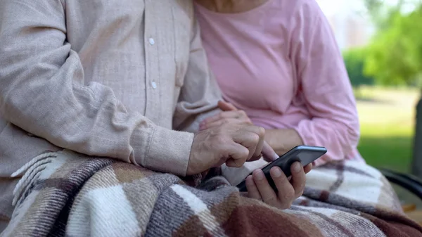 Συνταξιούχο Ζευγάρι Περιήγηση Πρόγραμμα Smartphone Κάθεται Στο Πάρκο Online Αίτηση — Φωτογραφία Αρχείου