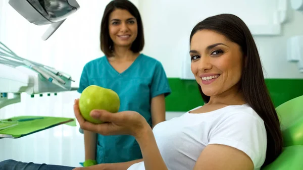 Señora Paciente Sosteniendo Manzana Verde Sonriendo Cámara Cuidado Dental Profesional —  Fotos de Stock