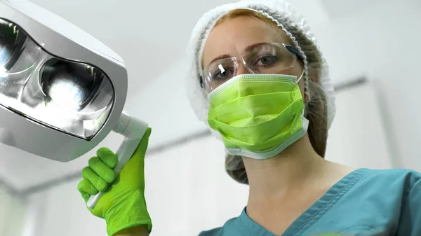 Sjuksköterska Bär Skydd Mask Glasögon Och Cap Justera Ljus Före — Stockfoto