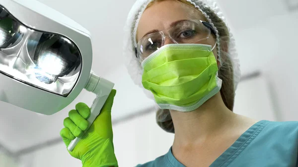 Lady Tandläkare Skyddande Uniform Justera Ljus Före Undersökning Närbild — Stockfoto