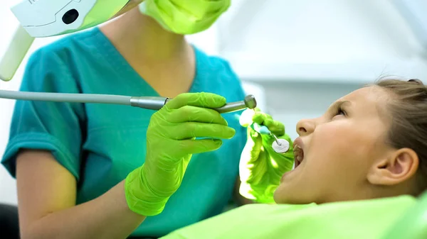 彼女の歯 齲蝕除去を治すために歯科医の椅子に座っている少女 — ストック写真