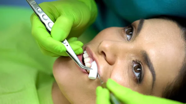 女性の患者の口からコットン ロールを取り出し口科医をクローズ アップ — ストック写真