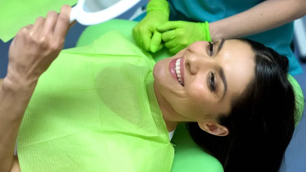 微笑的女性看镜子后密封胶放置 满意的病人 — 图库照片