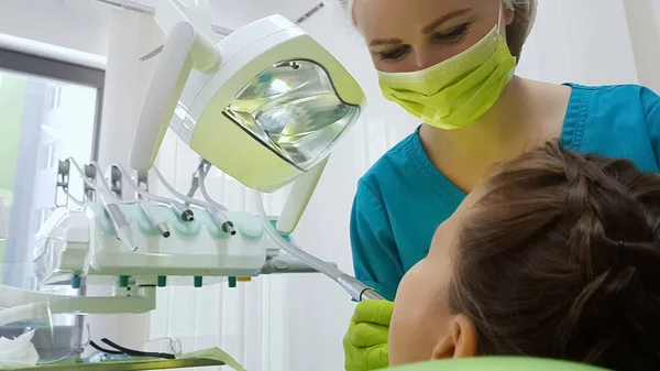 子供の歯 現代の小児口腔医学クリニックを慎重に掘削の歯科医 — ストック写真
