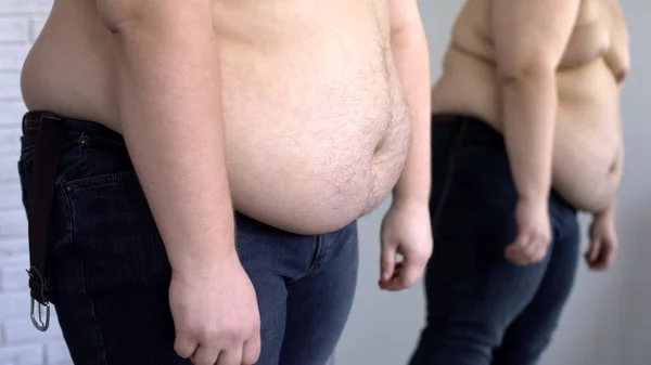 Απογοητευμένοι Παχύσαρκος Άνδρας Ψάχνει Στο Λίπος Στην Κοιλιά Κατοπτρική Ανάκλαση — Φωτογραφία Αρχείου