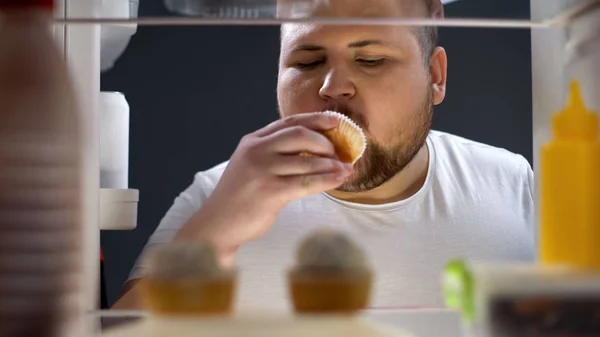 超重男子美味的纸杯蛋糕在夜间 饮食失败 不健康的生活方式 — 图库照片