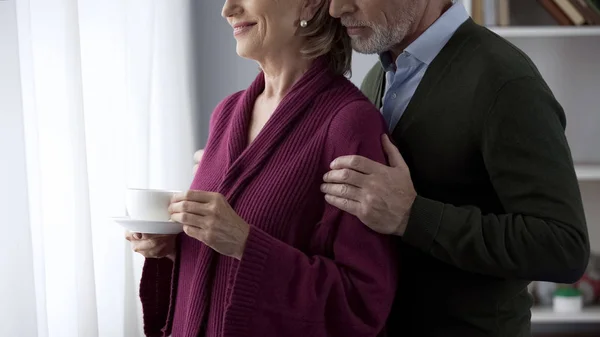 Altes Paar Schaut Fenster Dame Hält Tasse Tee Mann Umarmt — Stockfoto