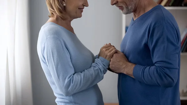 Homem Sênior Segurando Mãos Mulher Olhando Para Outro Sorrindo Flertando — Fotografia de Stock