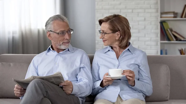 Jubilado Hombre Mujer Sentado Sofá Hombre Leyendo Periódico Mujer Disfrutando —  Fotos de Stock