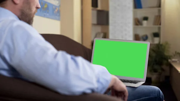 在绿色屏幕笔记本电脑上观看电影的成年男性 在网站上搜索工作 — 图库照片