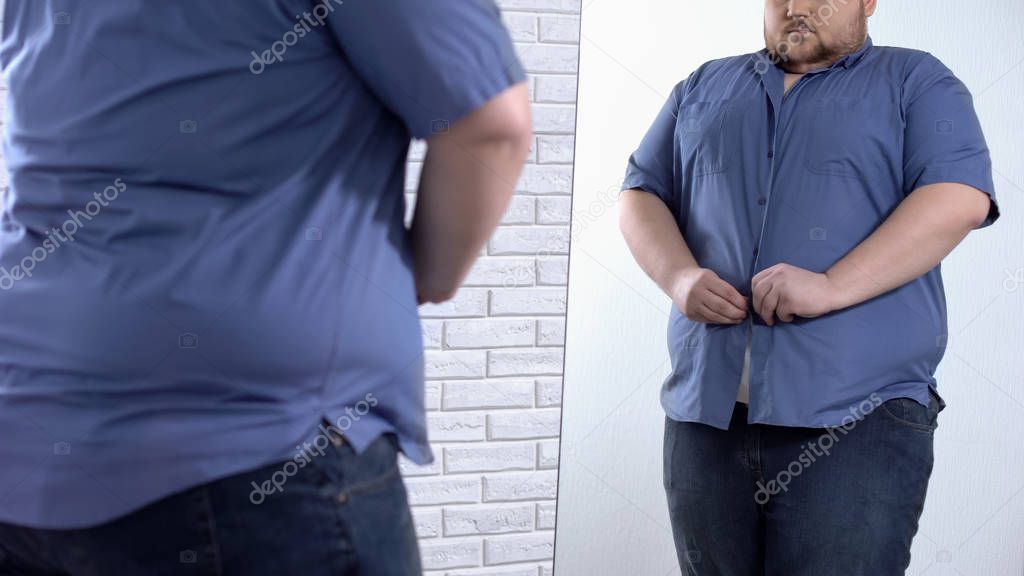 Plump man buttoning up tight shirt, oversize clothing problem, appearance
