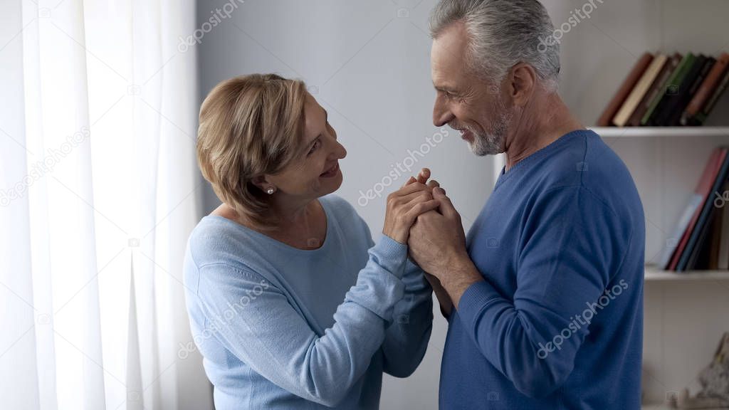 Happy aging couple looking at each other and smiling, trustful relationship