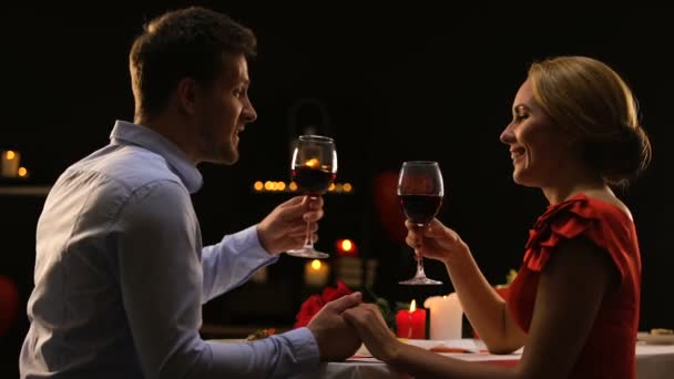 Sladké pár řinčí poháry s červeným vínem, datum v vysoce kvalitní restaurace