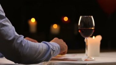 Genç adam yemeğe kırmızı şarap ile restoranda yalnız, bill getiren garson