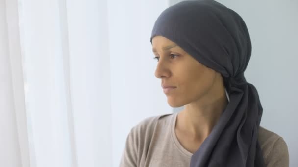 ウィンドウ リハビリ センター 致命的な病気を探してスカーフで動揺の女性 — ストック動画