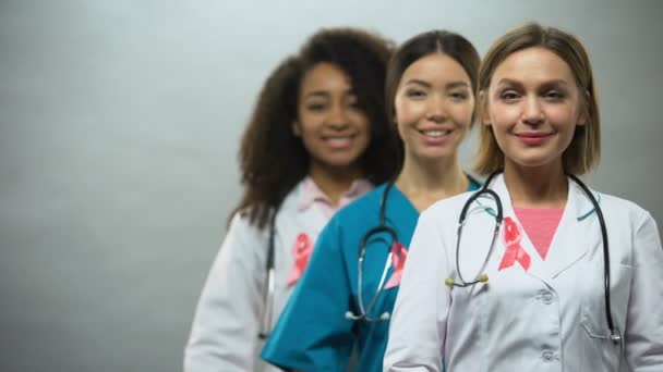 Χαμογελώντας Πολυφυλετικής Νοσηλευτές Ροζ Κορδέλες Διεθνή Μαστού Καρκίνος Σημάδι — Αρχείο Βίντεο