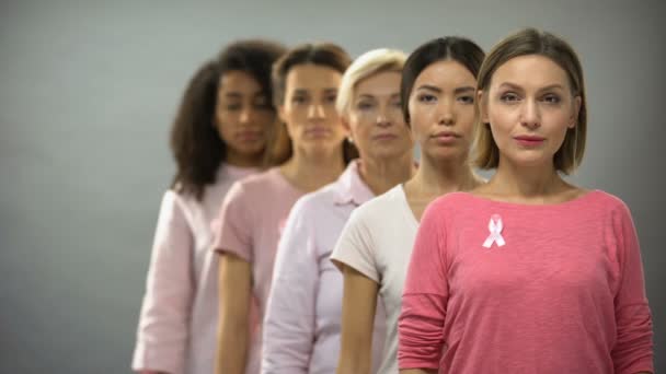 Серьезные Женщины Розовыми Лентами Информирования Раке Молочной Железы Стоят Ряд — стоковое видео