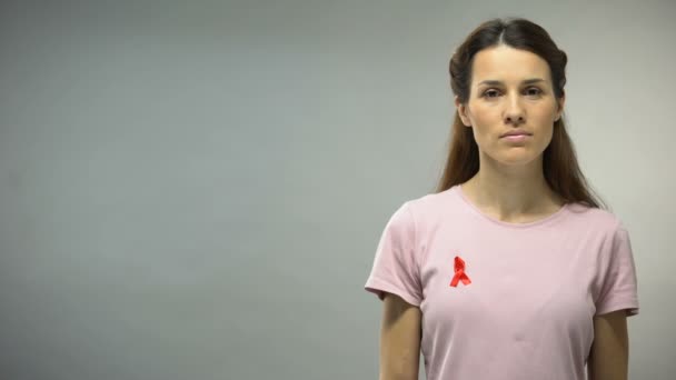 Młoda Kobieta Czerwoną Wstążką Koszuli Patrząc Aparacie Znak Świadomości Hiv — Wideo stockowe
