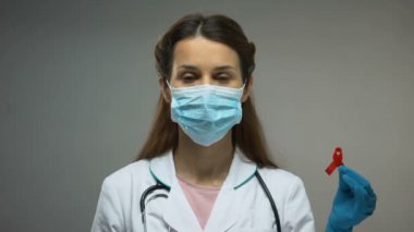 Laborant kırmızı kurdele ve kan örnekleri, gösterilen koruma maskesi yardımcıları