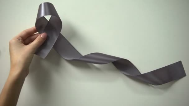 女士把灰色丝带放在桌子上 脑癌意识运动 — 图库视频影像