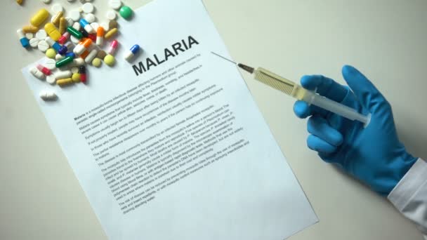 Malaria Wort Auf Papier Getippt Arzthand Mit Spritzentabletten Und Tabletten — Stockvideo