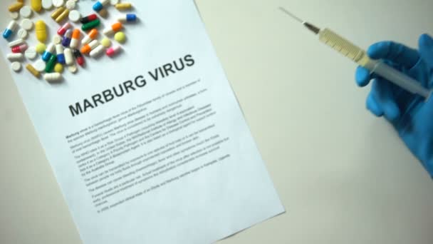 Marburg Virus Diagnose Papier Hand Met Spuit Pillen Tabletten Tafel — Stockvideo