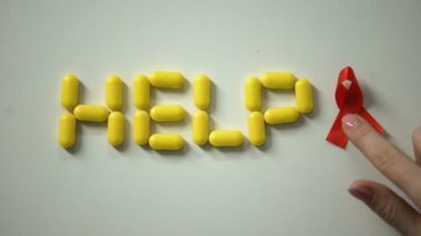 Hap masada, AIDS konusunda Bayan kırmızı kurdele yardım kelime yakınındaki koyarak yaptı