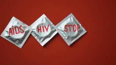 AIDS HIV prezervatif üzerinde kırmızı bir arka plan, önleme üzerinde kelime ve kırmızı kurdele kes