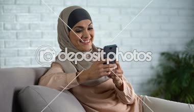 Sosyal kaydırma mutlu Arap erkek fotoğraf smartphone, ev hanımı boş zaman ağlar