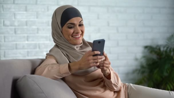 快乐阿拉伯女性滚动社交网络照片智能手机 家庭主妇休闲 — 图库视频影像