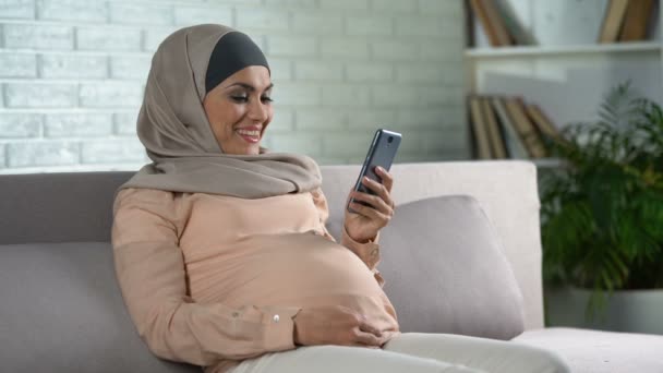 Muslim Pregnant Female Watching Video Smartphone Home Expecting Childbirth — Stock Video