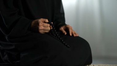 Dua mindere oturmuş, İslam boncuk sayma, AF isteyen Arap Erkek