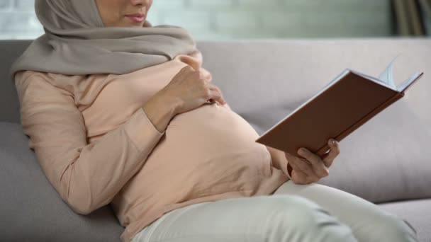Беременная Женщина Хиджабе Гладит Животик Читает Книгу Внутреннюю Гармонию Досуг — стоковое видео