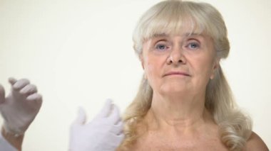 Yaşlı kadın hasta cilt, kırışıklık giderme, güzellik inceleyerek dermatolog