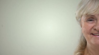 Mutlu gülümseyen yaşlı kadın sulu greyfurt, yarı-yüz closeup dilim gösterilen