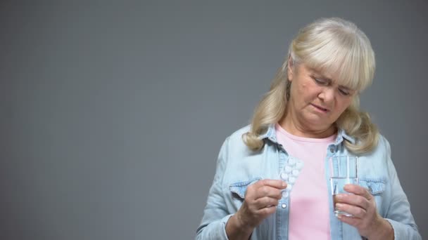 不快乐的老年女士拿着药丸不愿意服用 无效的药物 — 图库视频影像