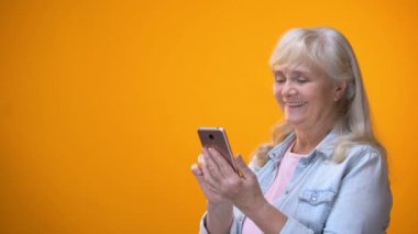 Gülümseyen yaşlı Bayan smartphone, modern teknoloji okuryazarlığı emekliler için yazarak