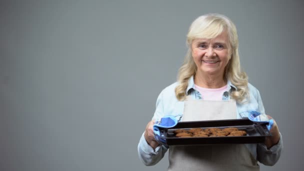 トレイ チョコレート クッキーをビジネス アイデアの家族の伝統を保持しているシニア女性 — ストック動画