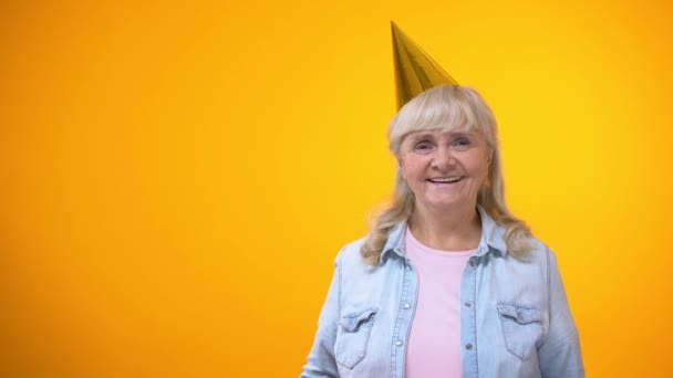 黄色の背景でバルーンを保持している幸せな笑みを浮かべて高齢者女性記念日 — ストック動画