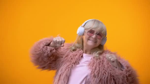 Positieve Bejaarde Dame Roze Jas Ronde Zonnebril Luisteren Naar Muziek — Stockvideo