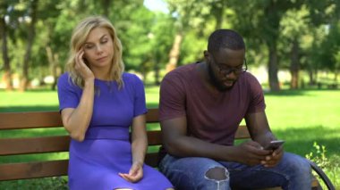 Afrika kökenli Amerikalı adam cep telefonu tarihte parkta oynarken üzgün kız arkadaşı yok sayılıyor