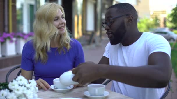 Πολυφυλετικές Γυναίκα Και Άντρα Πίνοντας Τσάι Και Μιλώντας Στο Υπαίθριο — Αρχείο Βίντεο