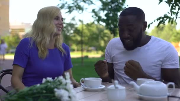 非裔美国人的男人告诉漂亮的女朋友在咖啡馆里的有趣的故事 — 图库视频影像